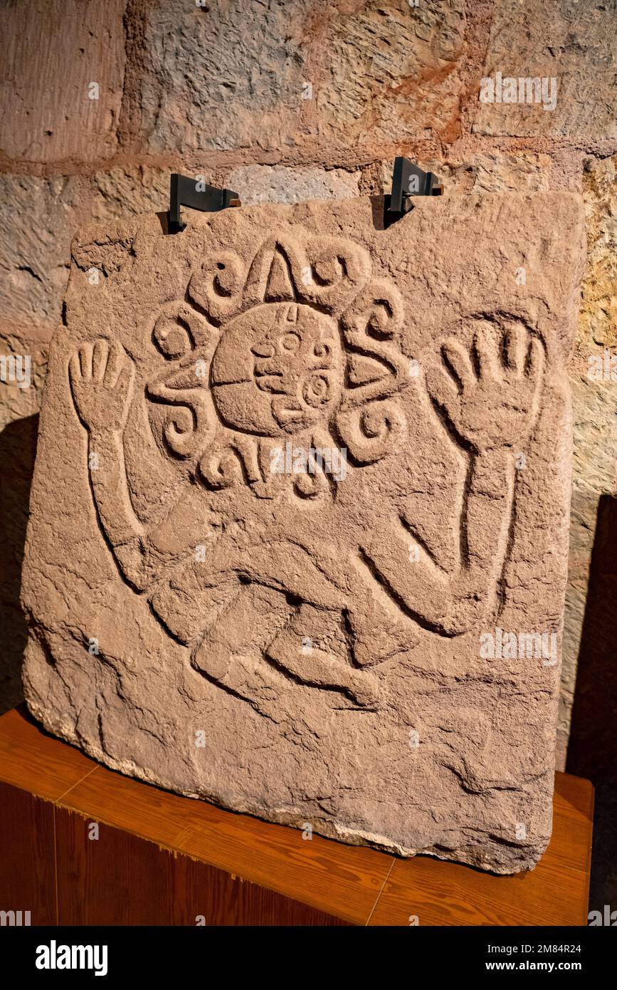 Prähispanischer Stein, der einen Mann zeigt, dessen Gesicht von der Sonne umgeben ist. Museum of Oaxacan Culture, Oaxaca, Mexiko. Stockfoto