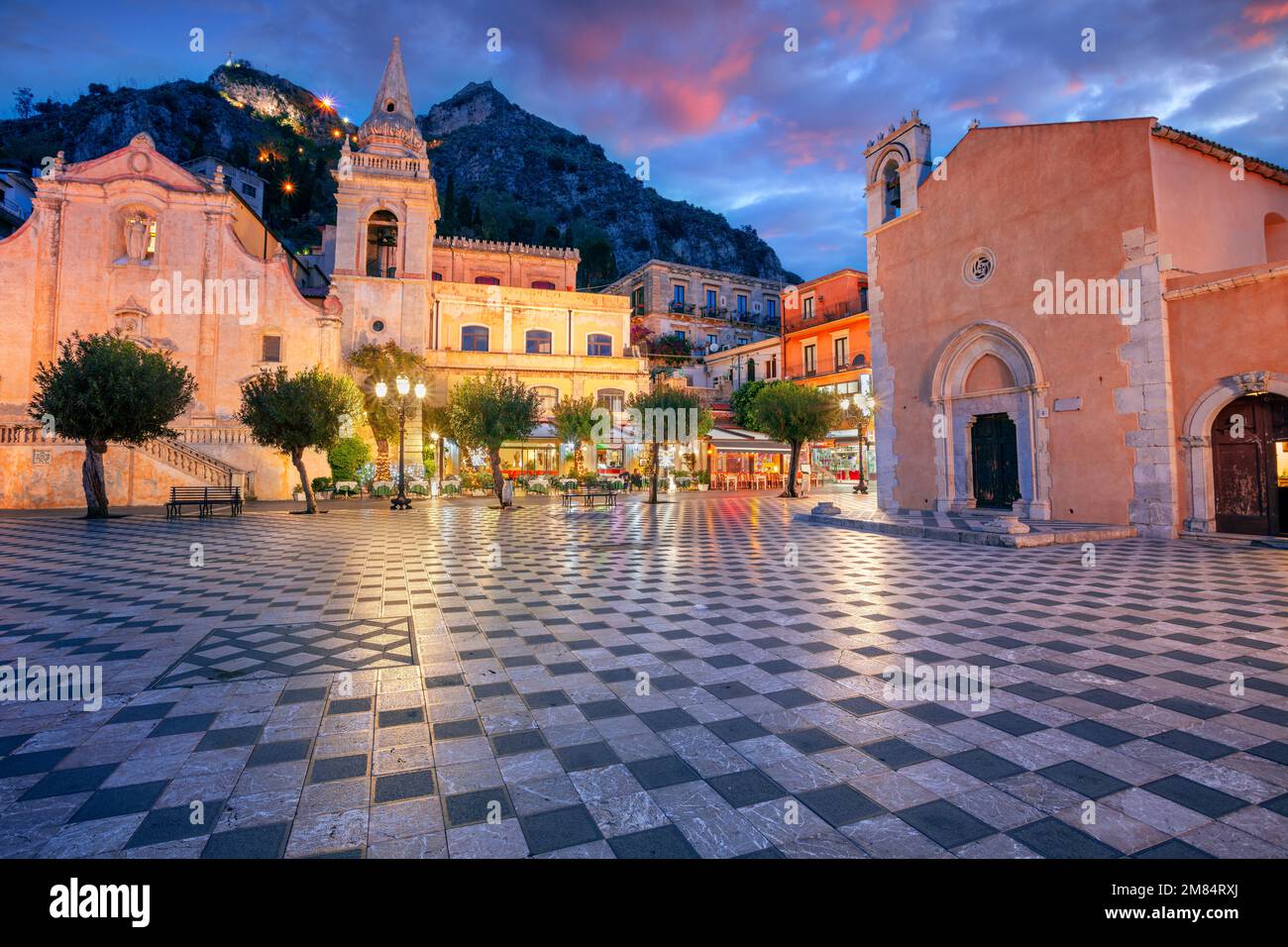 Taormina, Sizilien, Italien. Stadtbild der malerischen Stadt Taormina, Sizilien mit Hauptplatz Piazza IX Aprile und Kirche San Giuseppe bei Sonnenuntergang. Stockfoto