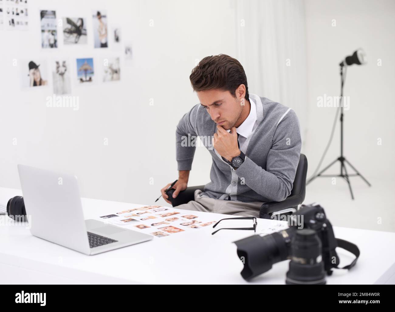 Ich Suche das Titelbild. Ein junger Fotograf, der an seinem Schreibtisch  sitzt und Bilder bearbeitet Stockfotografie - Alamy