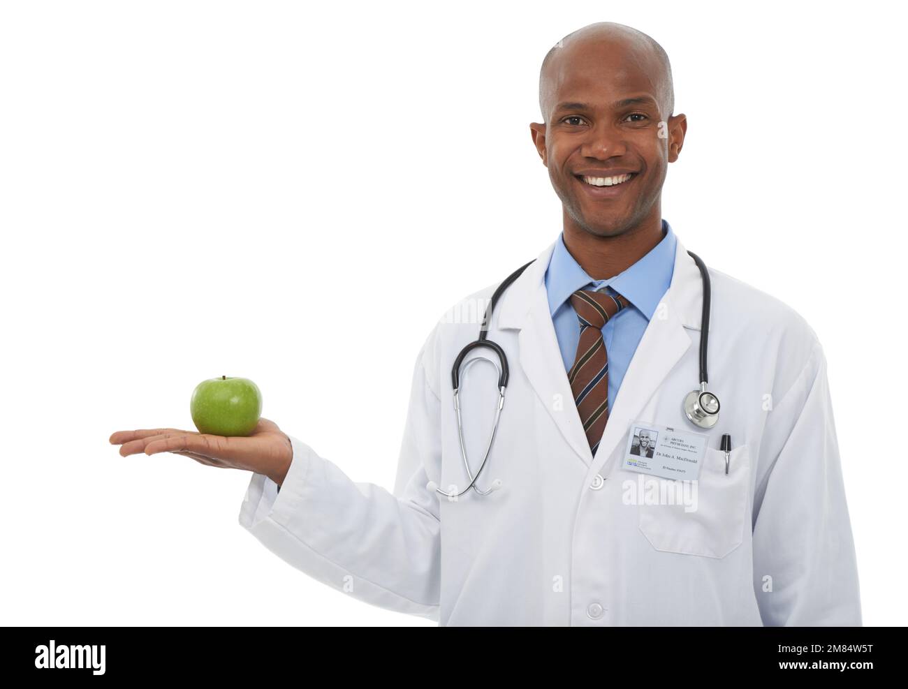 Denken Sie daran, eine gesunde Ernährung aufrecht zu erhalten. Zugeschnittenes Studiobild eines jungen Arztes mit einem Apfel. Stockfoto