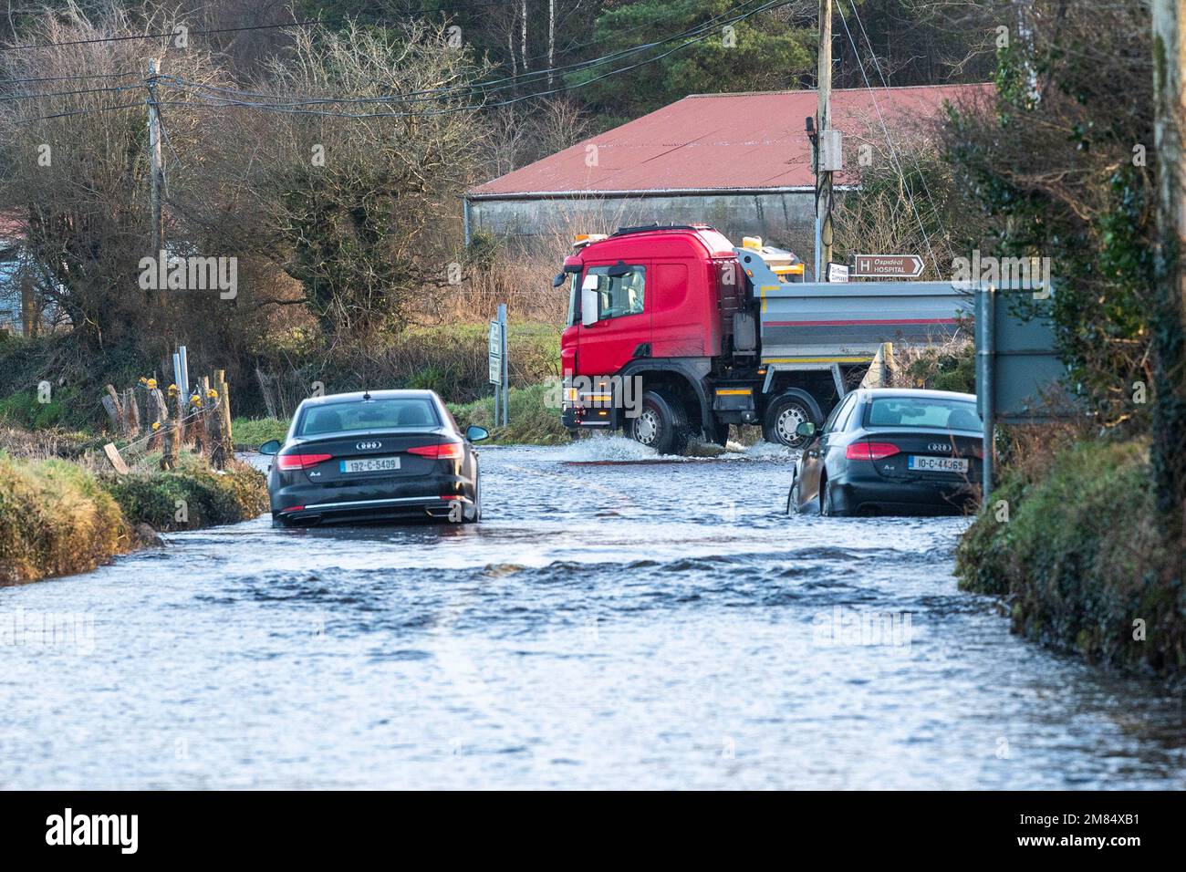 Dunmanway, West Cork, Irland. 12. Januar 2023. Die Straße Dunmanway R587 nach Macroom wurde heute Morgen überflutet, nach einer Nacht sintflutartigen Regens inmitten einer gelben Wetterwarnung von Meet Eireann. Zwei Autos wurden bei der Überschwemmung als verlassen gesehen, aber trotzdem fuhren Fahrzeuge durch das Hochwasser. Bild: Andy Gibson. Kredit: AG News/Alamy Live News Stockfoto