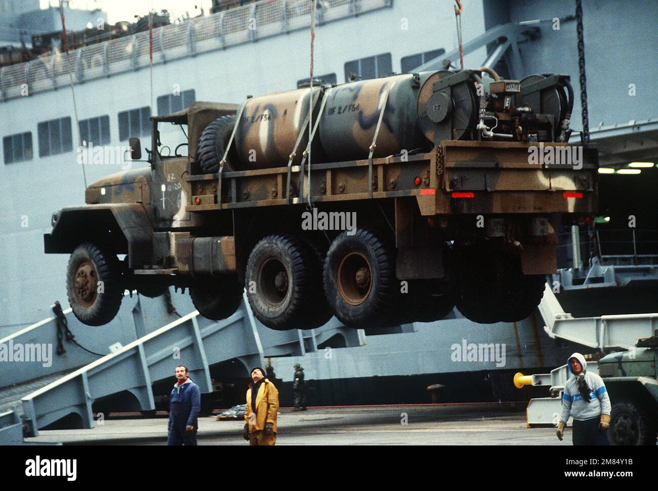 Ein M-813 5-Tonnen-Lkw mit Tankvorrichtung wird am Schiffsterminal Dundalk vom Fracht-/Schnellreaktionsschiff USNS ANTARES (T-AKR-294) entladen. Das Fahrzeug wurde von der 32. Infanterie-Brigade (mechanisiert), Wisconsin Army National Guard, während der Übung Reforger '86 benutzt. Basis: Baltimore Bundesstaat: Maryland (MD) Land: Vereinigte Staaten von Amerika (USA) Stockfoto