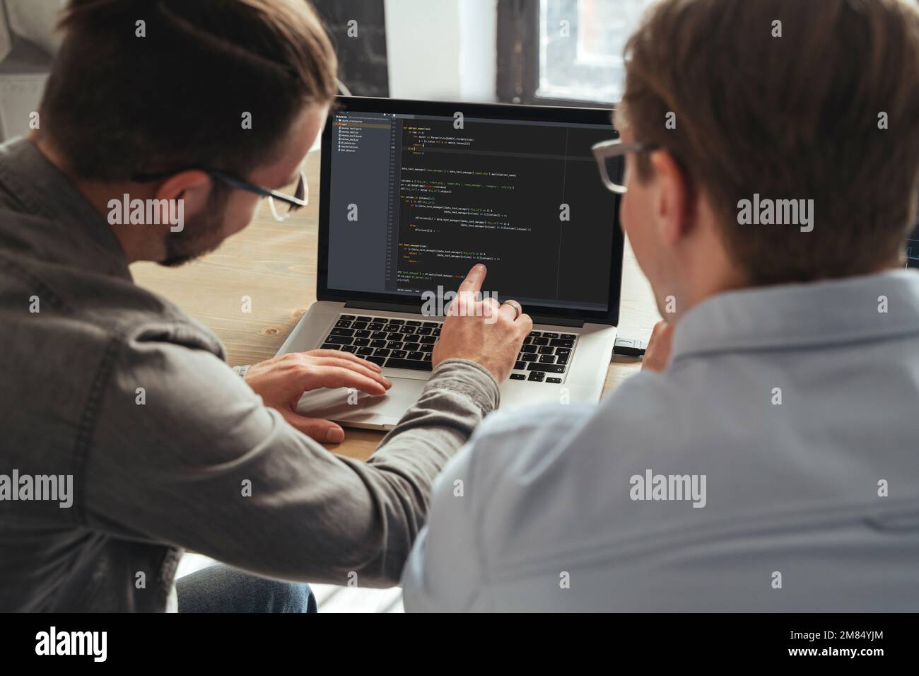 IT-Spezialist, der dem Menschen persönliche Programmierunterricht erteilt. Überblick über Programmierer, die gemeinsam an einem neuen Projekt arbeiten Stockfoto
