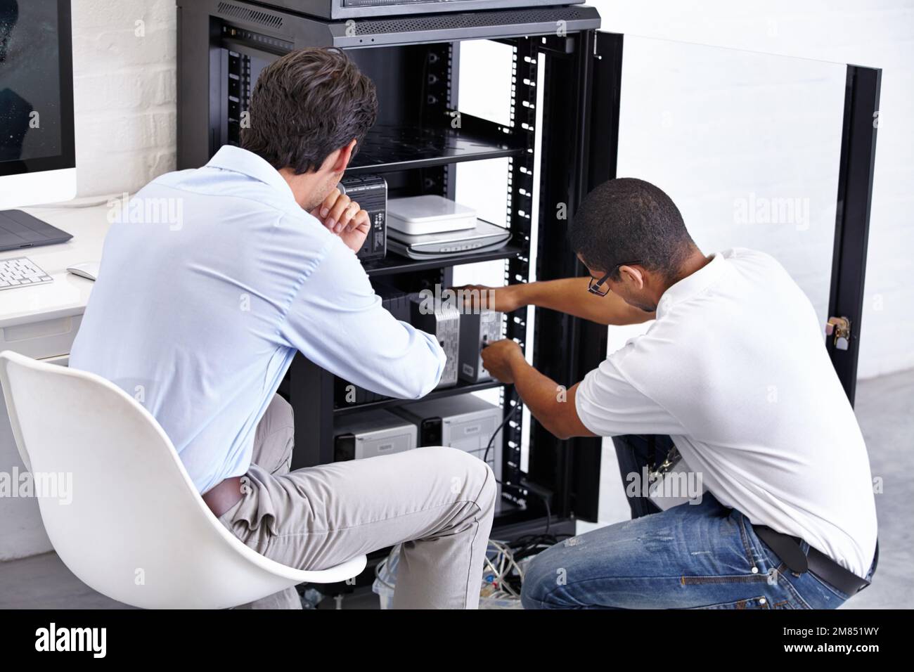 Ich leite technisches Fachwissen ein. Ein Techniker repariert das elektronische Gerät seiner Kunden. Stockfoto