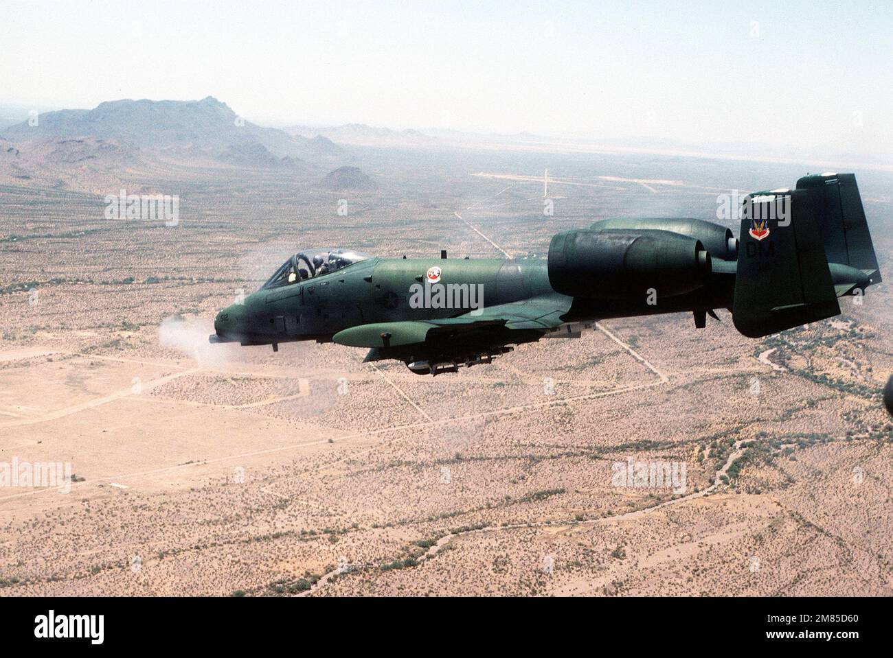 Eine Luft-zu-Luft-Ansicht von links eines taktischen 355.-Trainingsgeschwaders A-10 Thunderbolt II, bewaffnet mit einer AGM-65 Maverick-Rakete, die ihre GAU-8/A Avenger 30mm-Kanone über die Gila Bend-taktische Reichweite abfeuert. Land: Unbekannt Stockfoto