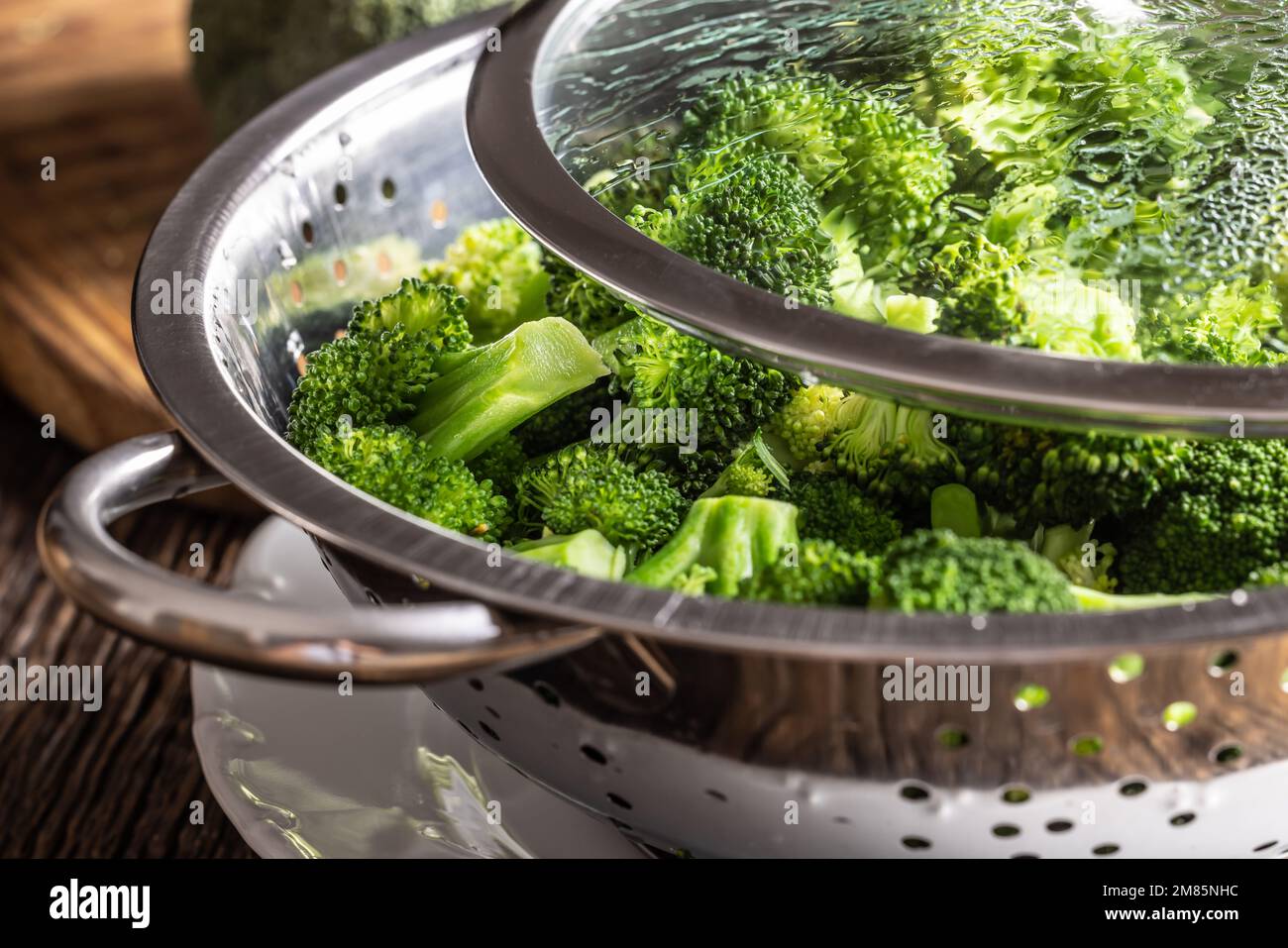 Gedämpfter Brokkoli in einem Dampfgarer aus Edelstahl mit Deckel – Nahaufnahme. Gesundes Gemüsekonzept. Stockfoto