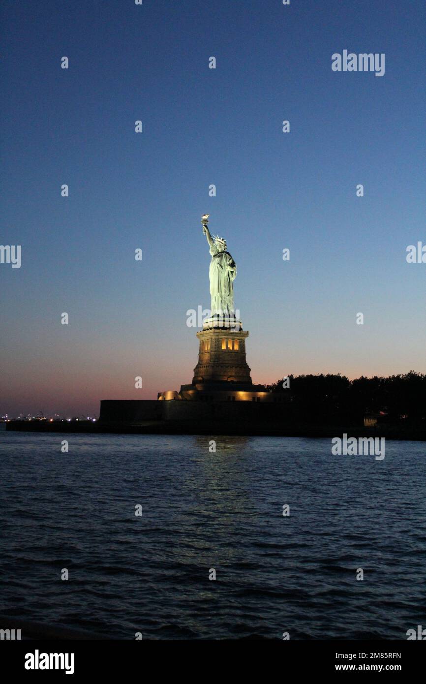 Wunderschöner Blick auf die Stadtlandschaft von New York und die Freiheitsstatue bei Sonnenuntergang Stockfoto