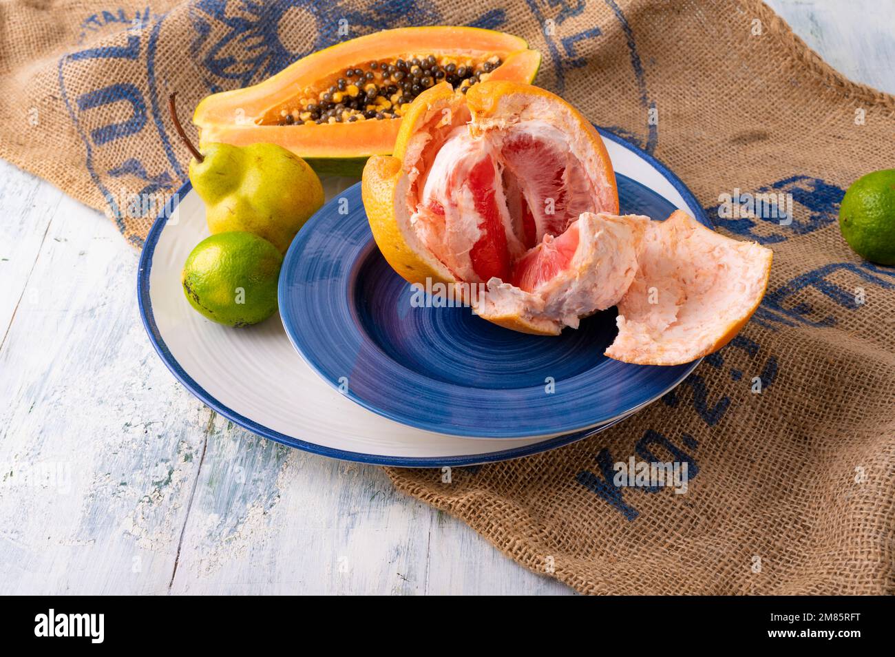 Stillleben mit Grapefruit-Papaya-Limette und Birne Stockfoto