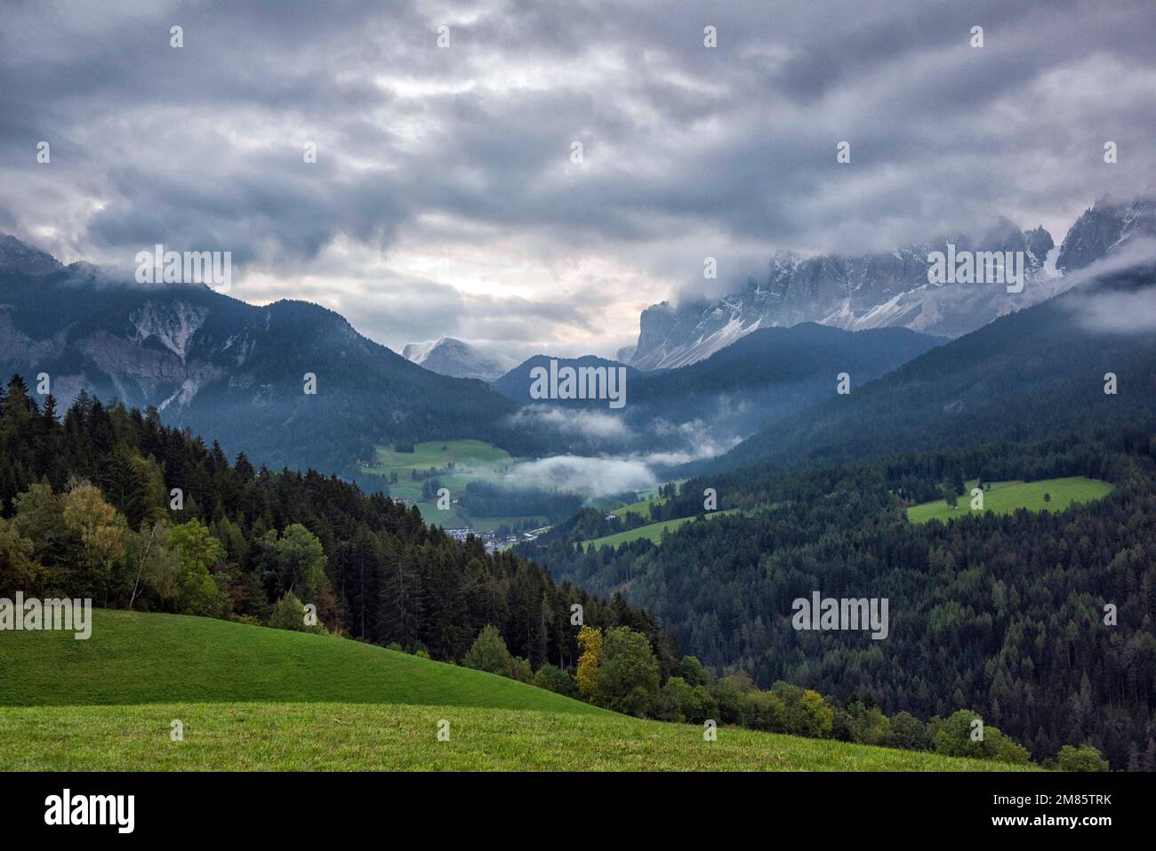 Am frühen Morgen schwirrt der Nebel über den Berggipfeln im Val di Funes in den Dolomiten, Italien, Europa Stockfoto