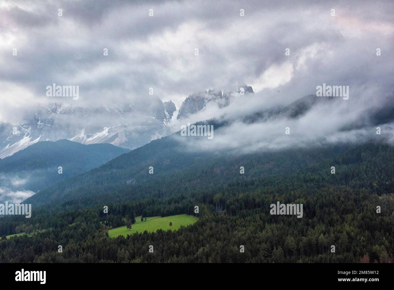 Am frühen Morgen schwirrt der Nebel über den Berggipfeln im Val di Funes in den Dolomiten, Italien, Europa Stockfoto