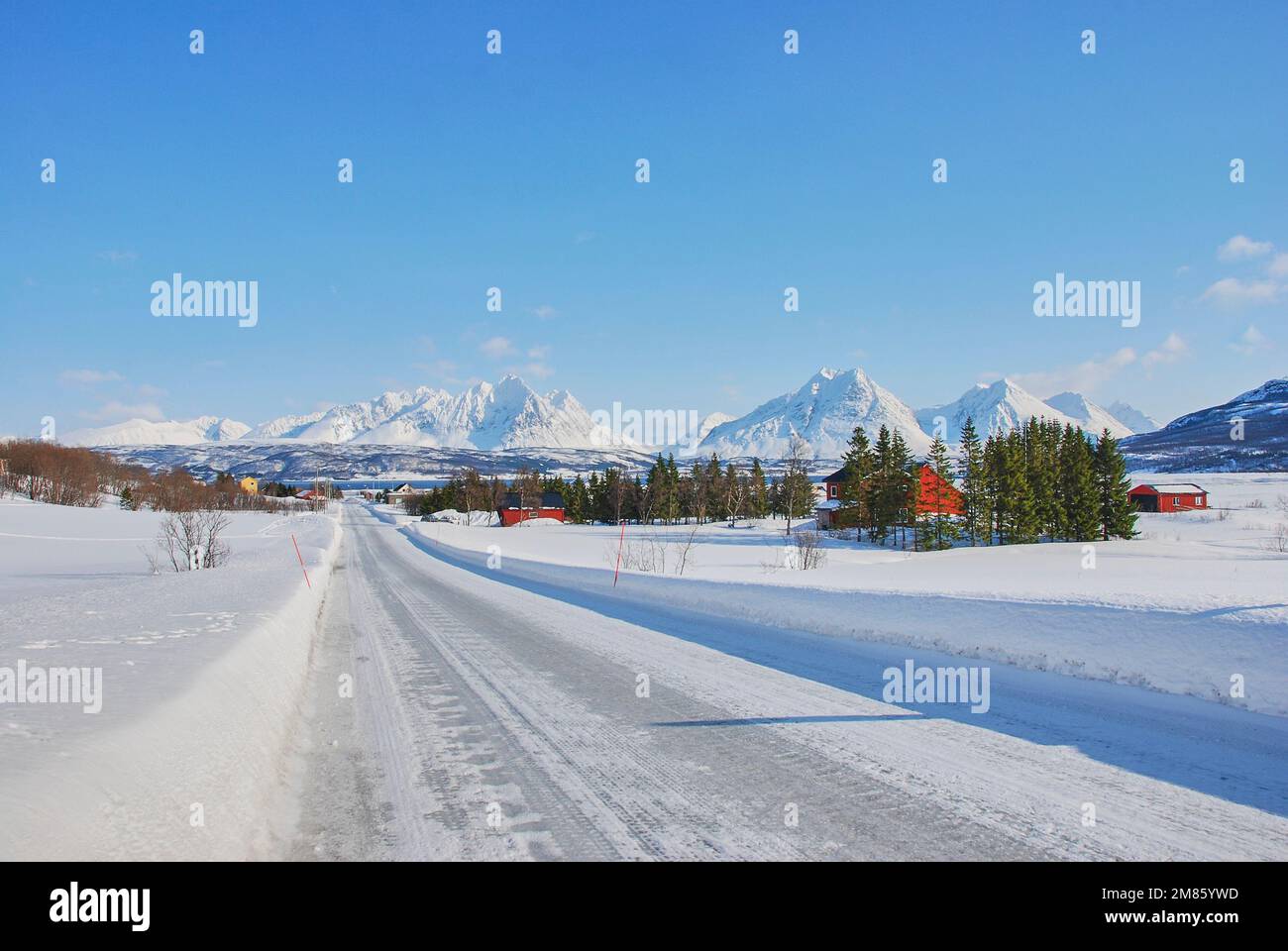 Winterlandschaft mit schneebedeckten Bergen und einer eisigen Straße im Norden Norwegens in der Nähe von Tromso Stockfoto