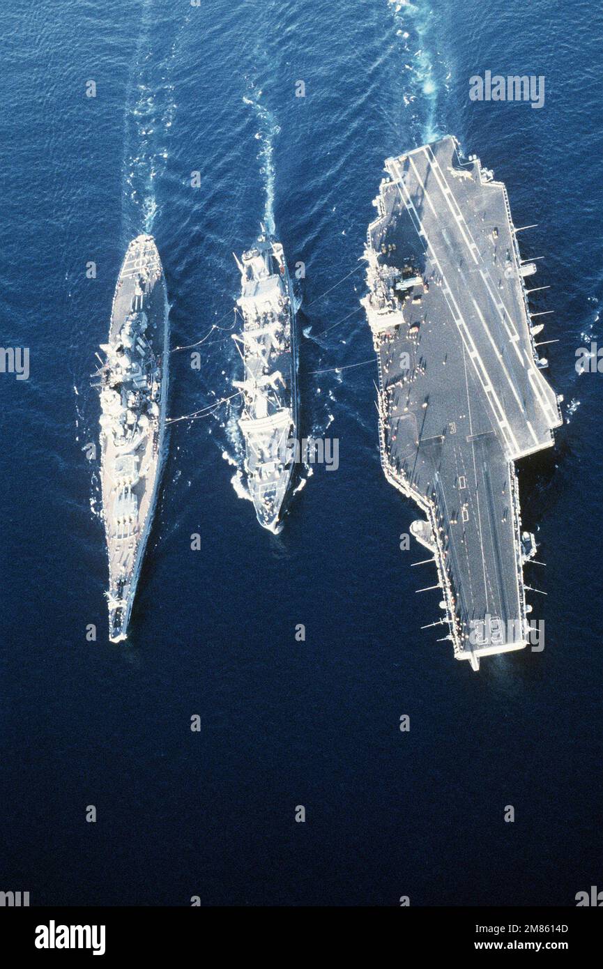 Eine Luftbogenansicht des Flottenölers USNS KAWISHIWI (T-AO-146), der eine laufende Auffüllung mit dem Schlachtschiff USS MISSOURI (BB-63) und dem Flugzeugträger USS KITTY HAWK (CV-63) durchführt. Land: Unbekannt Stockfoto