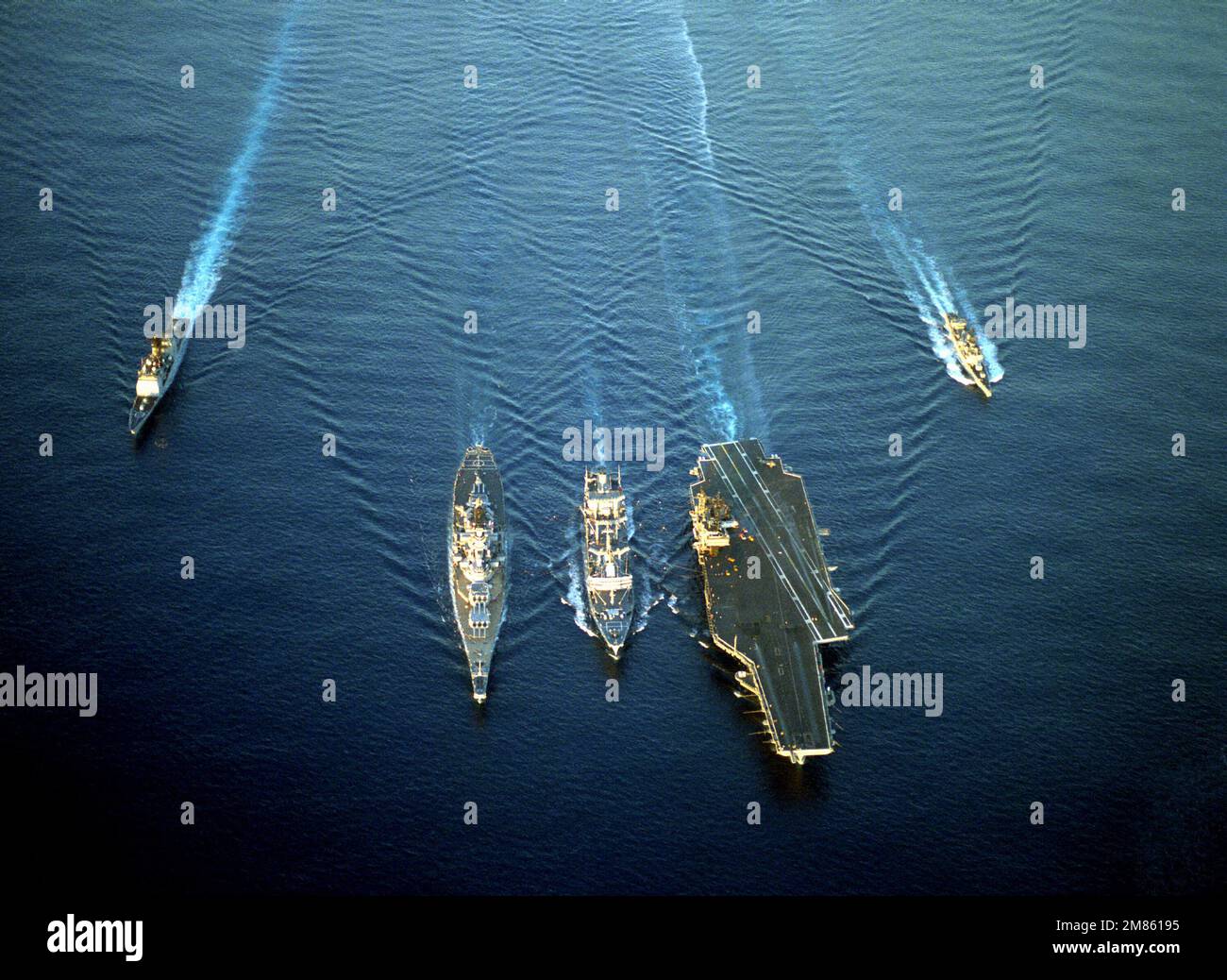Eine Luftbogenansicht eines militärischen Sealift-Kommandoschiffs und der USA Marineschiffe im Einsatz. Es handelt sich dabei von links nach rechts um den geführten Raketenkreuzer USS VALLEY FORGE (CG-50), das Schlachtschiff USS MISSOURI (BB-63), den Flottenöler USNS KAWISHIWI (T-AO-146), den Flugzeugträger USS KITTY HAWK (CV-63) und die geführte Raketenfregatte USS RAMSEY (FFG-2). Land: Unbekannt Stockfoto