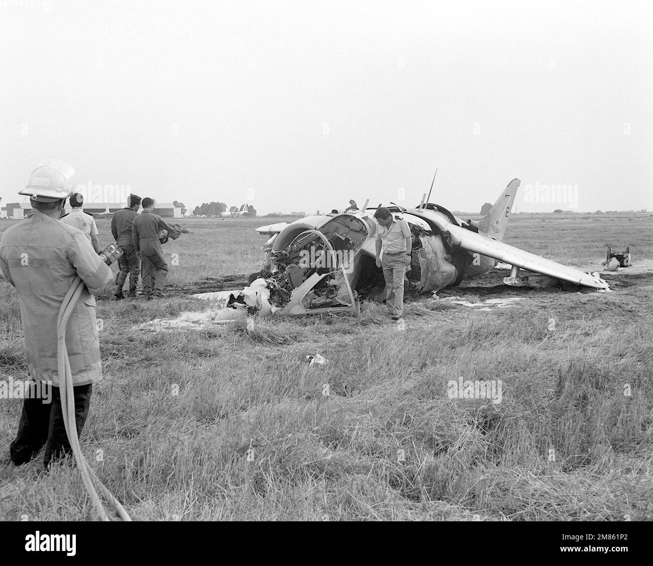 Die Ermittler sehen sich die Trümmer eines spanischen AV-8 Harrier-Flugzeugs an, während ein Feuerwehrmann daneben steht. Basis: Marinestützpunkt, Rota-Land: Spanien (ESP) Stockfoto
