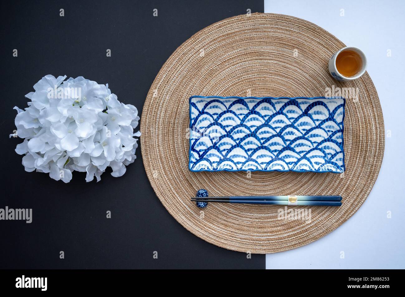 Japanischer oder chinesischer Tisch mit traditioneller Tischdecke und Essgeschirr mit Hintergrund und weißem Hintergrund. Speise- und Restaurantkonzept. Flach verlegt. Stockfoto