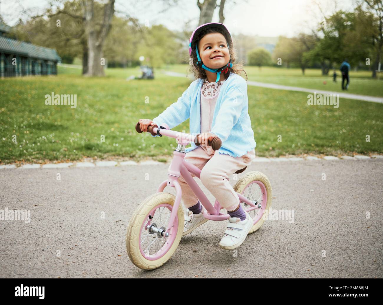 Radfahren, Denken und Kind auf einem Fahrrad im Park, Outdoor-Aktivitäten und Lernen in Neuseeland. Sport, Glück und Mädchen, die auf dem Fahrrad spielen Stockfoto