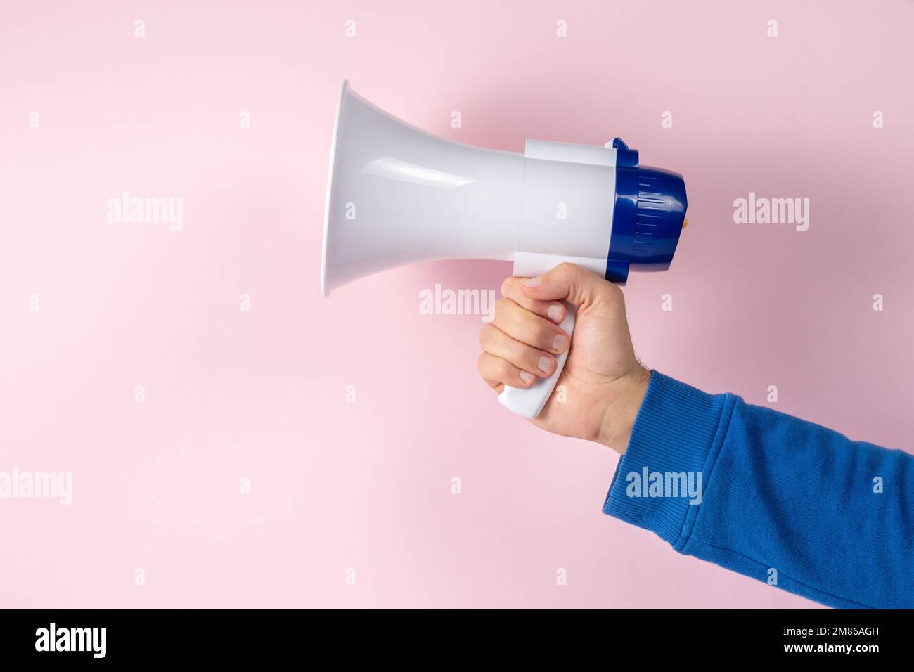 Megafon in der Hand auf hellem Hintergrund. Kreatives Ankündigungskonzept. Stockfoto