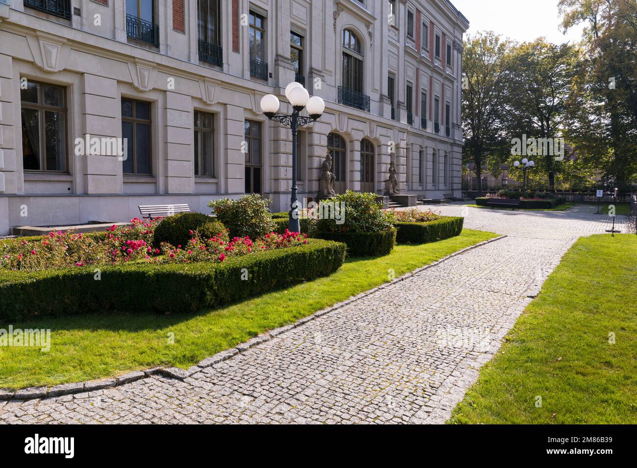 Eine Gartenlampe in einem Park inmitten grüner Hecken. Stockfoto