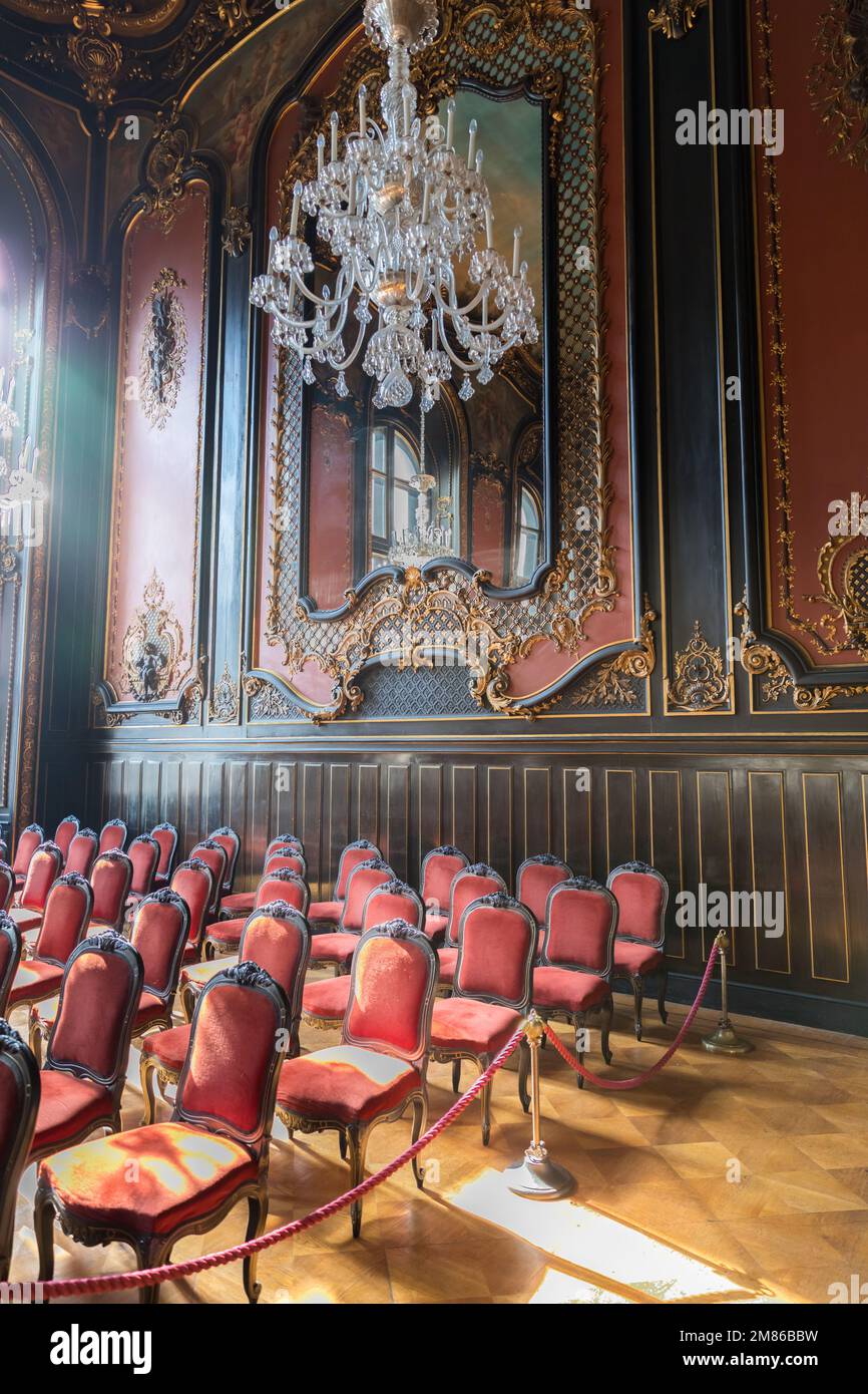 Leerer Konzertsaal mit klassischer Musik, stilvolle Stühle und ein großer Kristallleuchter. Stockfoto