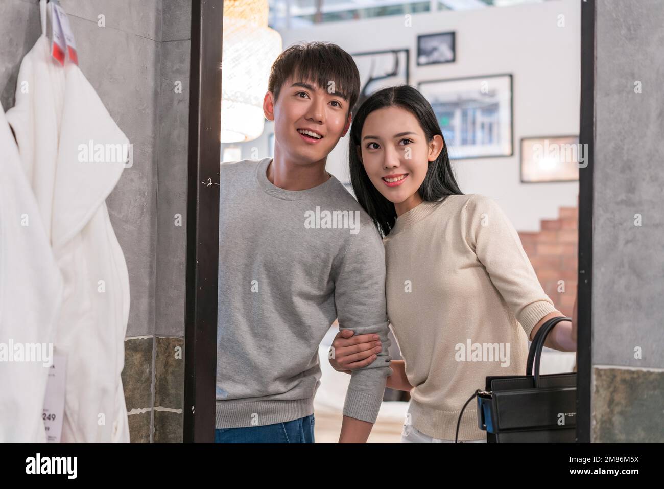 Das junge Paar, das vor dem Spiegel steht Stockfoto