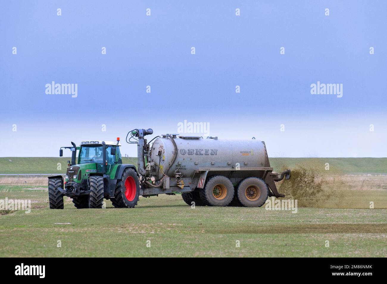 Landwirt im Fendt 818 Schlepper mit Drckstreuer verteilt/verteilt  Flssigdnger als Dnger im Frhjahr ber das Feld Stockfotografie - Alamy