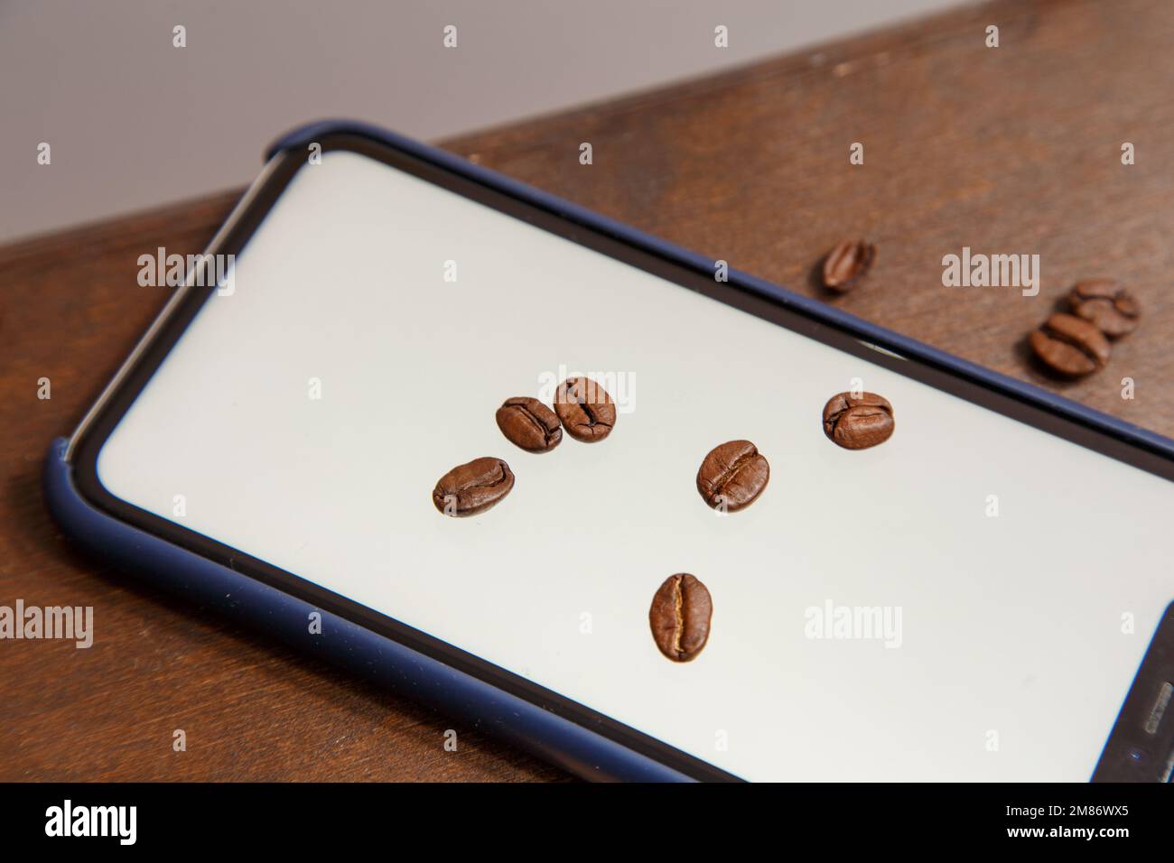 Der Türke steht auf einem Laptop, Kaffeebohnen sind überall verstreut und ein Telefon mit einer weißen Farbe im Inneren. Hochwertiges Foto Stockfoto