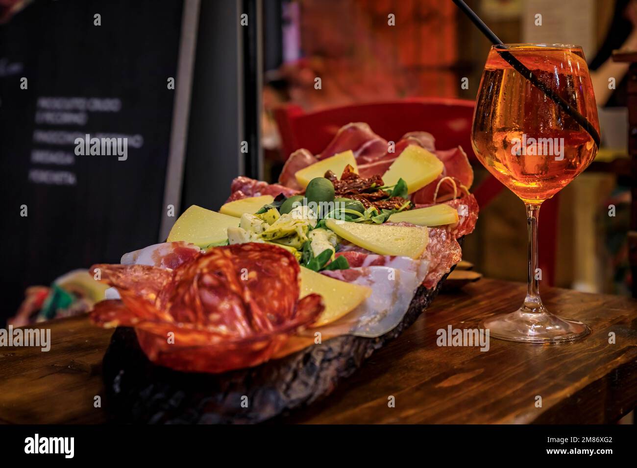 Italienische Vorspeisenplatte mit Prosciutto, Salami, Käse, Oliven serviert mit einem Glas aperol Spritz Cocktail in einem Restaurant in Florenz, Italien Stockfoto