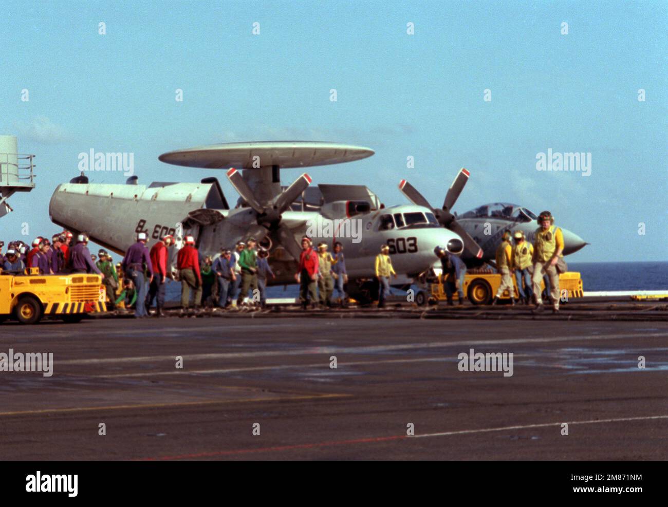 Die Besatzungsmitglieder des Cockpits stehen vor einem 2C Hawkeye-Flugzeug, während sie sich darauf vorbereiten, die Absturzbarrikade an Bord des nuklearbetriebenen Flugzeugträgers USS THEODORE ROOSEVELT (CVN-71) zu heben. Land: Unbekannt Stockfoto