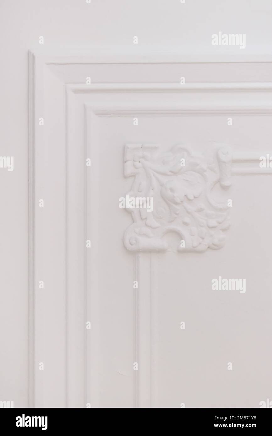 Eine weiße Tür mit kunstvollem Design auf der Vorder- und Seitenverkleidung in weißer Farbe, die so aussieht wie sie Stockfoto