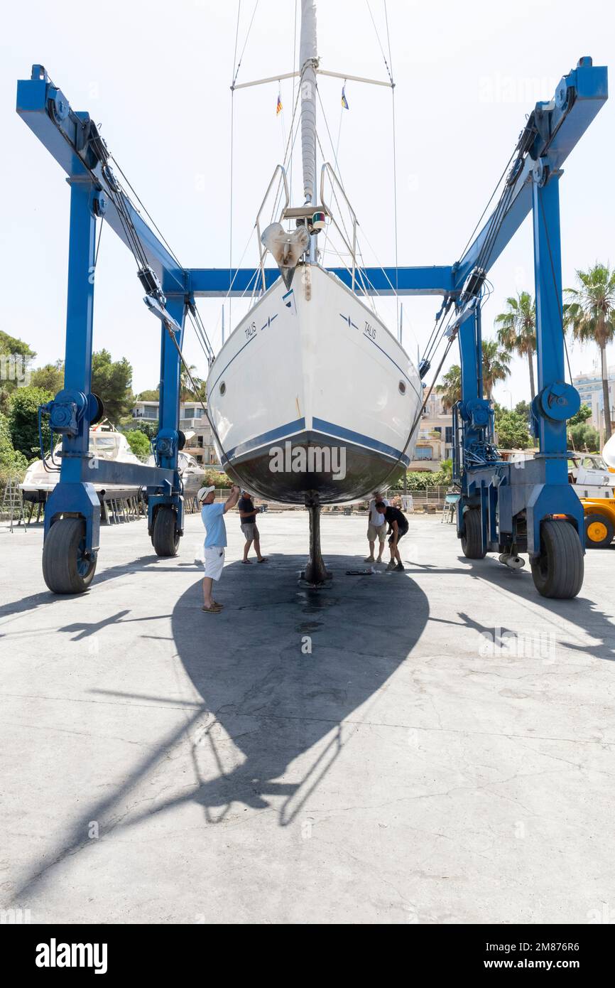 In der Werft von Porto Cristo, Mallorca, hebt ein Kran dieses Segelschiff zur Inspektion an Land. Stockfoto