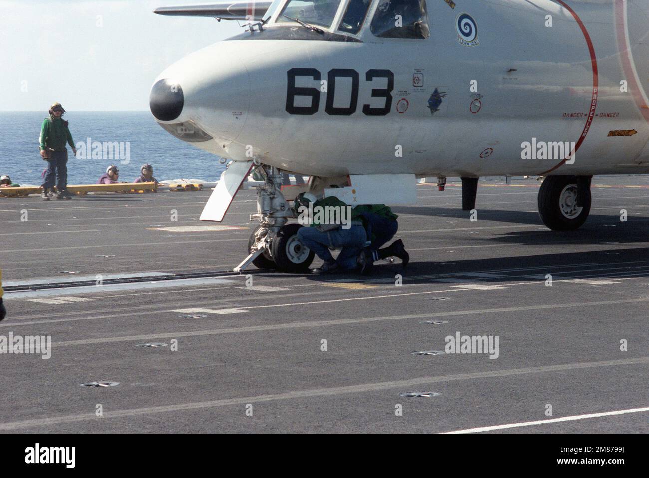 Katapultbesatzungen befestigen eine Haltebügel an der Nasenhalterung eines Hawkeye-Flugzeugs der Baureihe E-2C im Cockpit des nuklearbetriebenen Flugzeugträgers USS THEODORE ROOSEVELT (CVN 71). Das Luftfahrzeug gehört zum Carrier Airborne Early Warning Squadron 123 (VAW-123), Teil von Carrier Air Wing 1 (CVW-1), das dem Flugzeugträger USS AMERICA (CV 66) zugeordnet ist. Basis: USS Theodore Roosevelt (CVN 71) Stockfoto