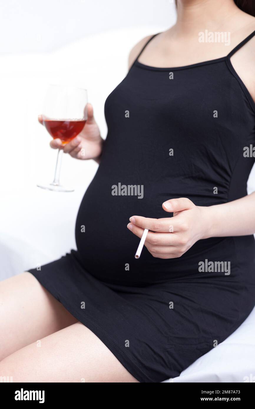 Ungesunde Essgewohnheiten, schwangere Frauen schwangere Frauen mit Alkohol und Tabak Stockfoto