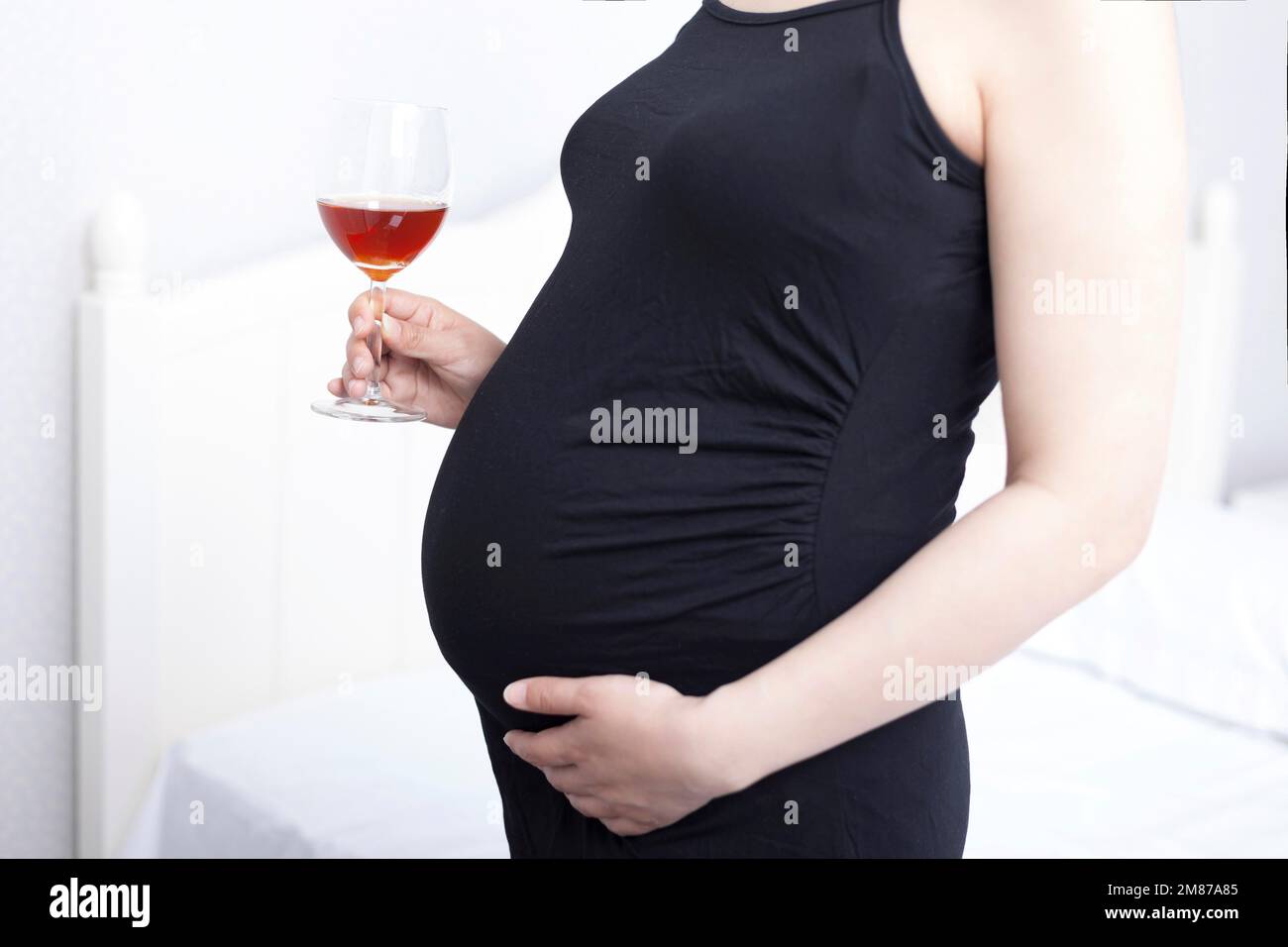 Ungesunde Essgewohnheiten, schwangere Frauen schwangere Frauen mit Wein Stockfoto