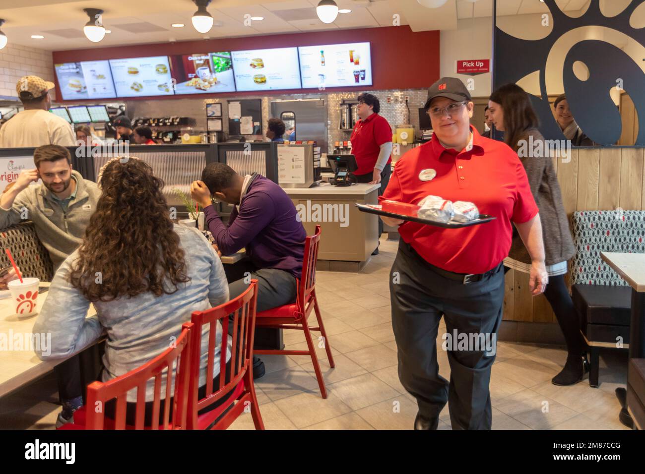Livonia, Michigan – Ein Mitarbeiter von Chick-fil-A liefert am Tag der großen Eröffnung des Restaurants eine Bestellung an einen Tisch. Stockfoto
