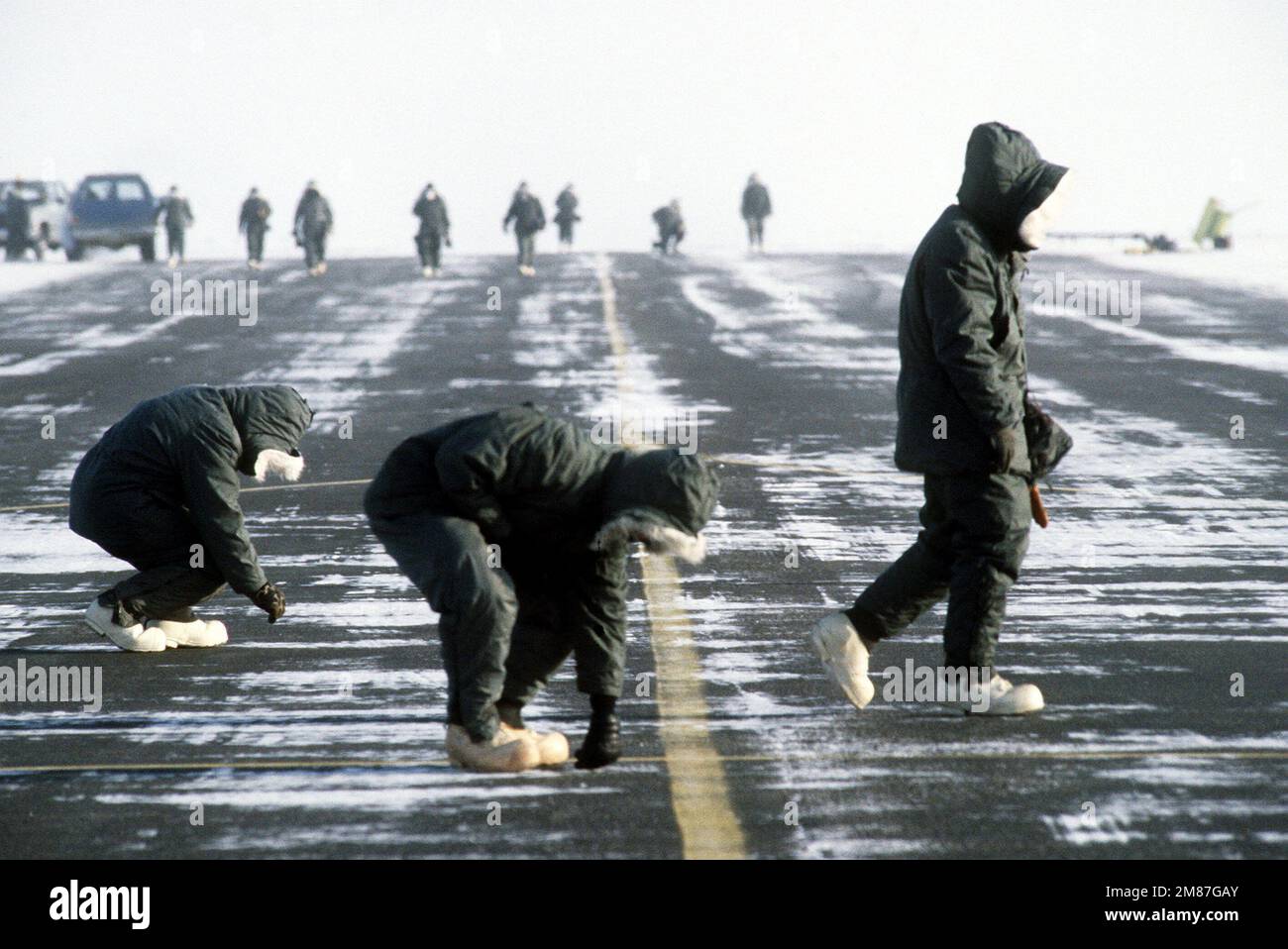 Mitglieder der 43. Aircraft Maintenance Unit führen während der Übung Cobbler Freeze '87, einer Kaltwetterübung, die vom Alaska Air Command durchgeführt wird, einen FOD (Foreign Object Damage Damage)-Spaziergang über die Landebahn durch. Betreff Operation/Serie: COBBLER FREEZE '87 Base: Deadhorse State: Alaska (AK) Country: United States of America (USA) Stockfoto