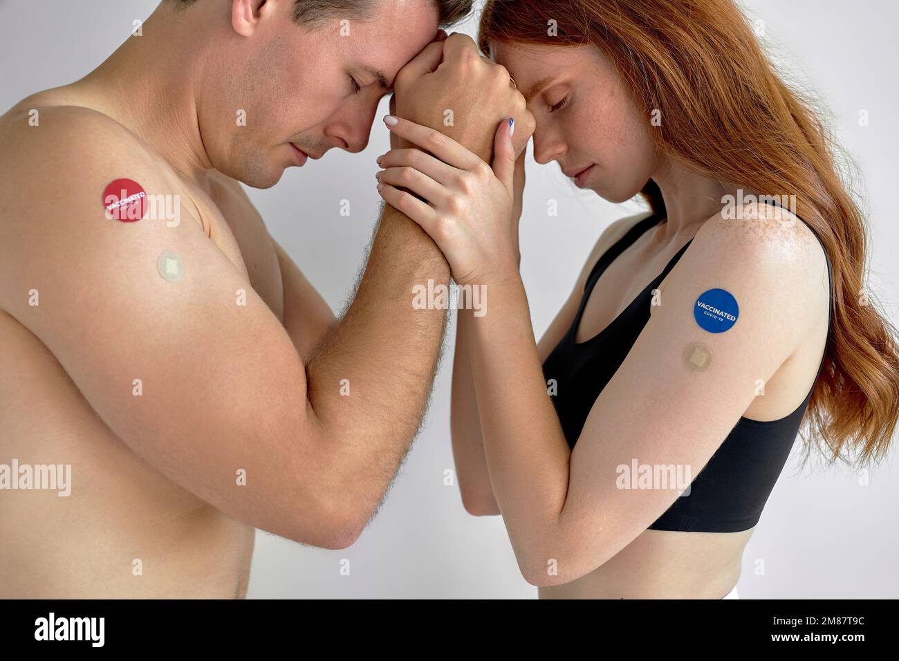 Junges weißes Paar zeigt COVID-19-Impfstoff am Arm im Konzept eines globalen Coronavirus-Impfprogramms zur Impfung der Bürger. Porträt von Shirtles Stockfoto