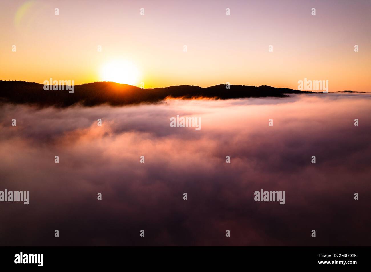 Luftaufnahmen von Sonnenaufgang über Wolken, Nebelbank, Wolkenmeer, wunderschöne Ruhe, friedlicher Sonnenaufgang am Morgen. Stockfoto