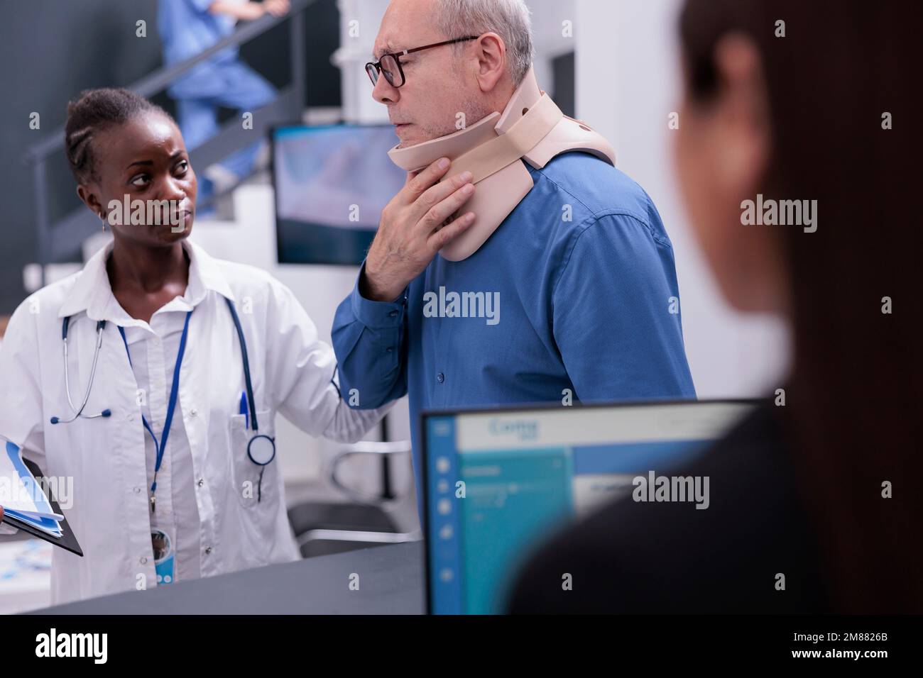 Älterer Patient mit Halsband, der dem Arzt im Wartebereich des