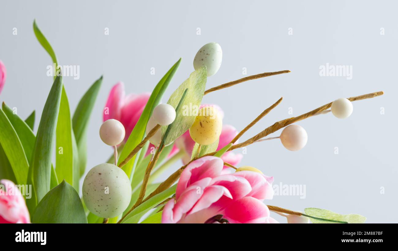 Frischer Strauß rosafarbener Tulpen mit einem Zweig ostereier auf weißem Hintergrund mit Kopierbereich Stockfoto
