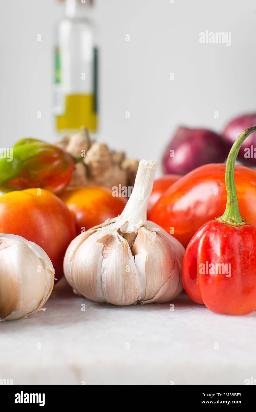 Knoblauchknolle und Scotch-Paprika auf einem Marmortablett, Knoblauchknolle, roher Knoblauch und heißer Paprika, Allium sativum Stockfoto