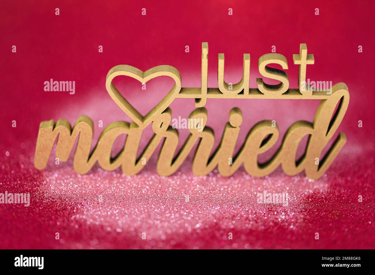 Hochzeitssymbol. Gerade verheiratete Inschrift auf pinkfarbenem Fuchsia-Hintergrund Stockfoto