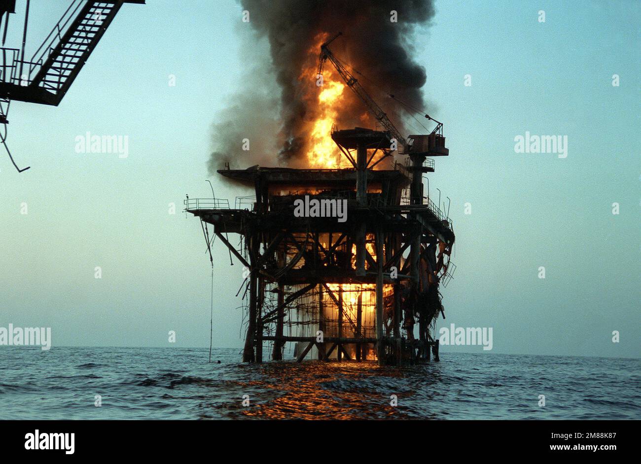 Eine iranische Führungs- und Kontrollplattform wird in Brand gesetzt, nachdem sie von vier US-Bürgern beschossen wurde Zerstörer der Navy. Der Bombenanschlag ist eine Reaktion auf einen kürzlich erfolgten iranischen Raketenangriff auf einen umgefackelten kuwaitischen Supertanker. Land: Unbekannt Stockfoto