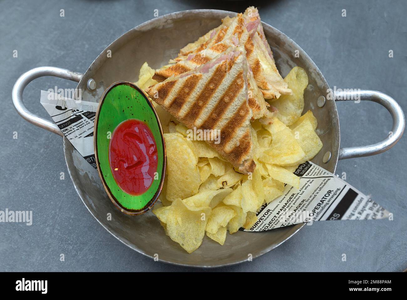 Toast mit Schinken und Käse mit Chips und Ketchup in einer Metallschüssel, Bayern, Deutschland Stockfoto