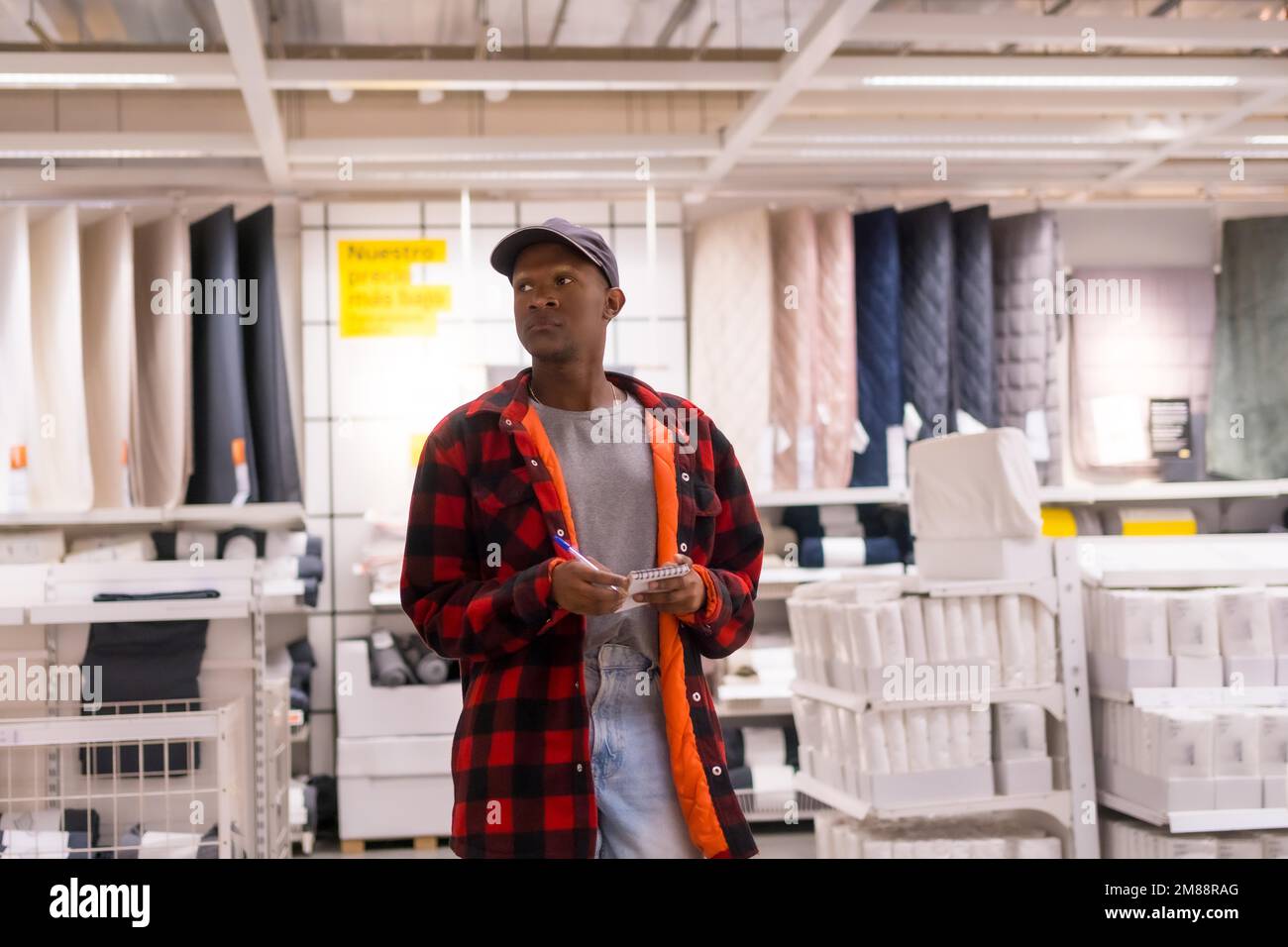 Schwarzer ethnischer Mann, der in einem Supermarkt Teppiche und Handtücher einkauft Stockfoto