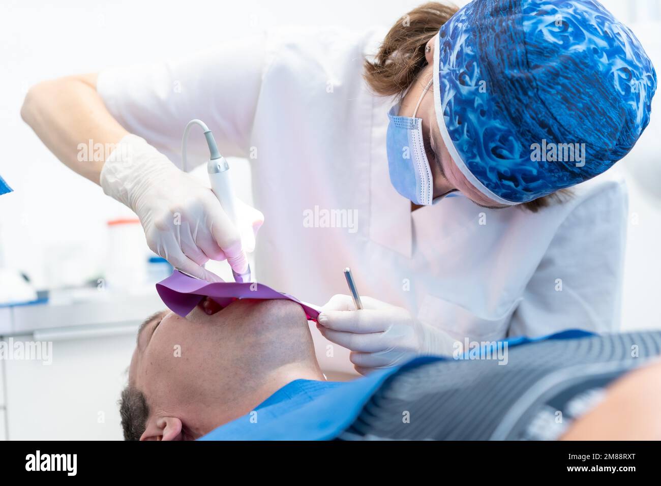 Zahnklinik, ein Arzt, der einem Patienten bei Volloperation einen Wurzelkanal vorführt Stockfoto