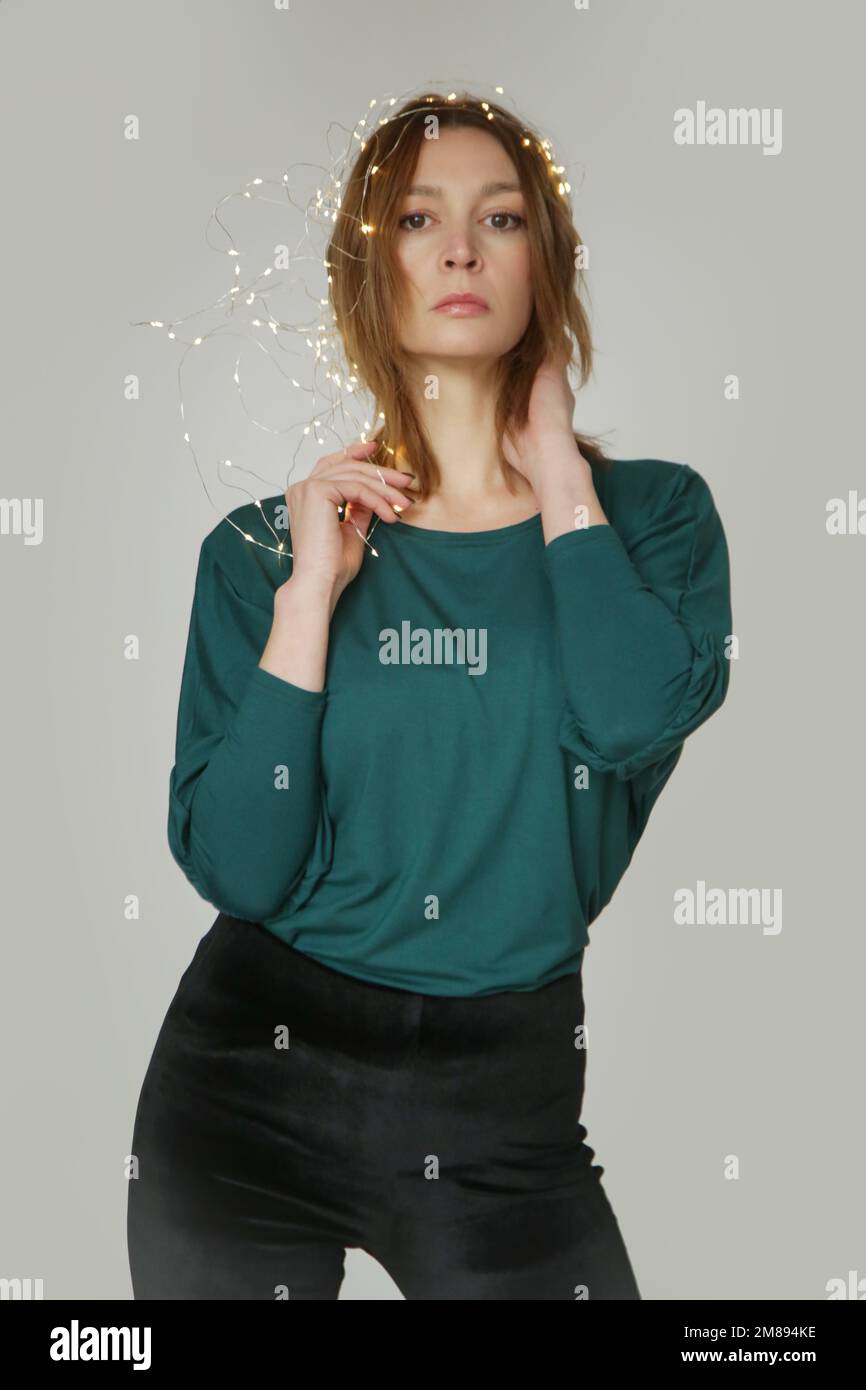 Studiofoto eines jungen weiblichen Models, das ein grünes langärmeliges Hemd aus biologischer Baumwolle trägt. Bequeme, nachhaltige Mode. Stockfoto