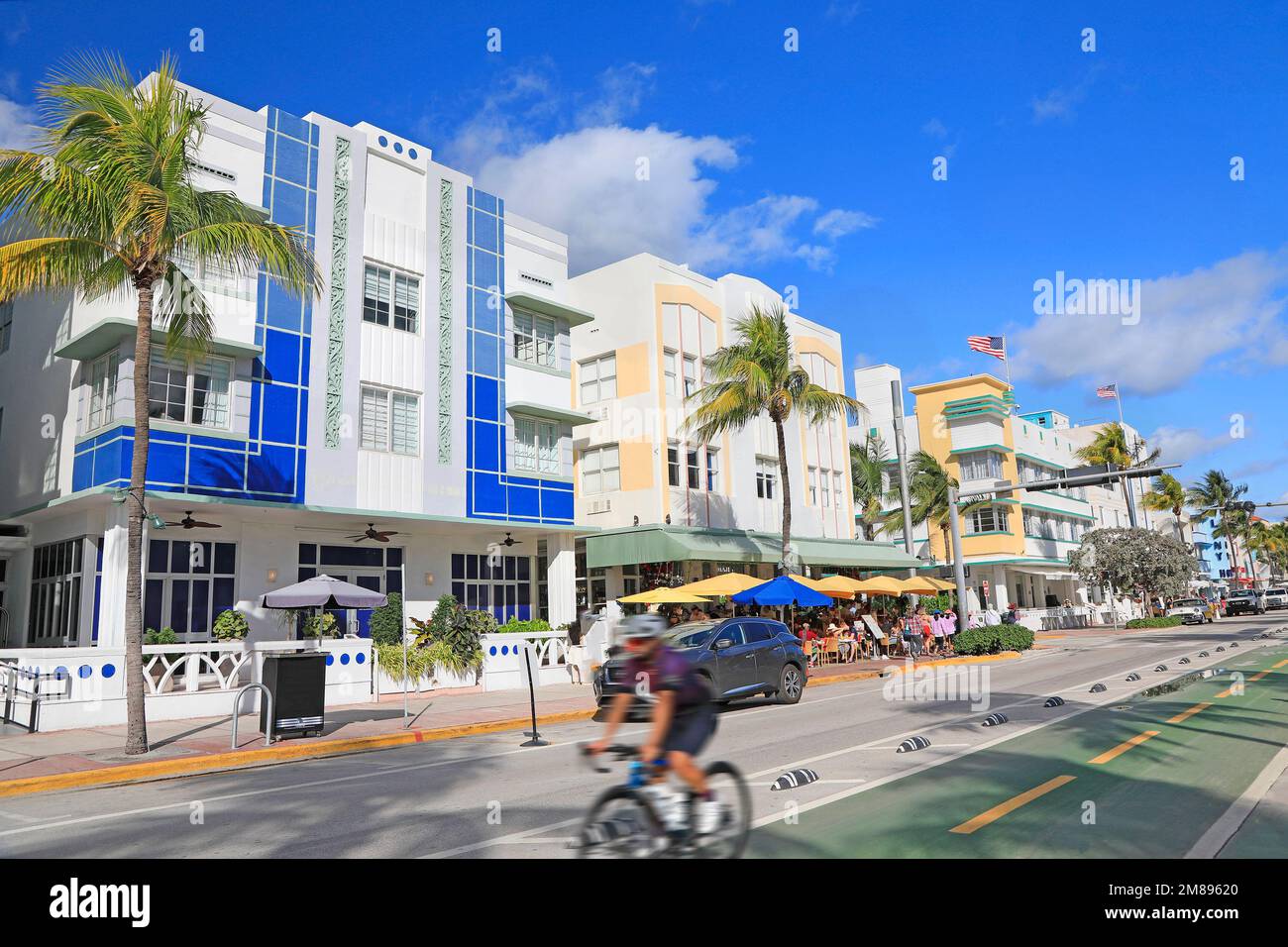 Farbenfrohe Art déco-Hotels und Radfahrer am Ocean Drive in Miami Beach, Florida, USA Stockfoto