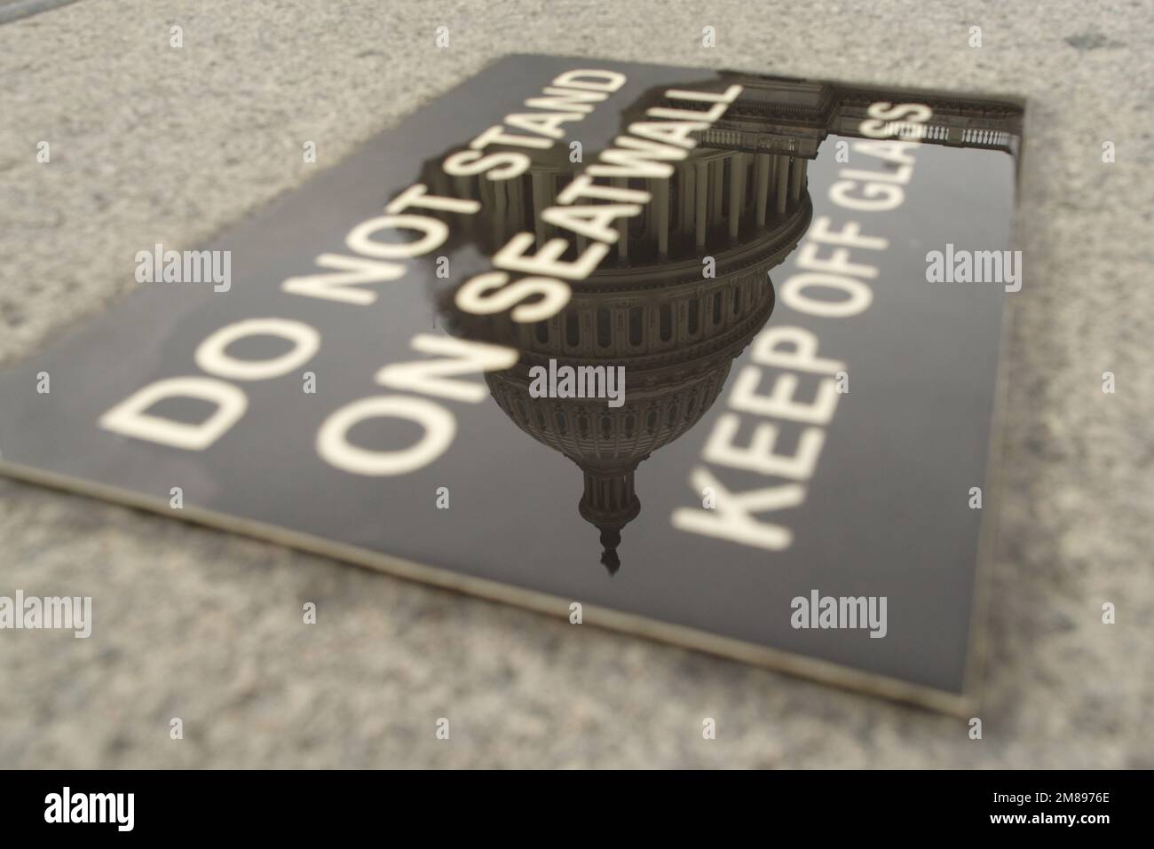 Die USA Das Capitol spiegelt sich nach einem Regenfall auf einem Schild wider. Stockfoto