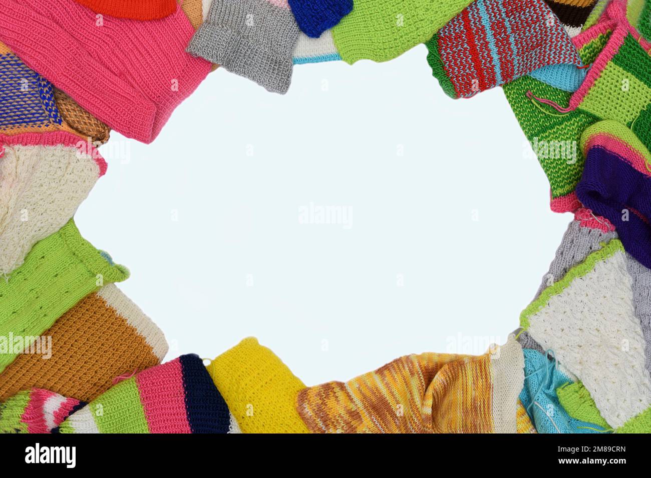 Eine Draufsicht einer Montage aus farbenfrohen, handgefertigten Wollgegenständen in Form eines ovalen Wolls auf einem sauberen weißen Hintergrund Stockfoto