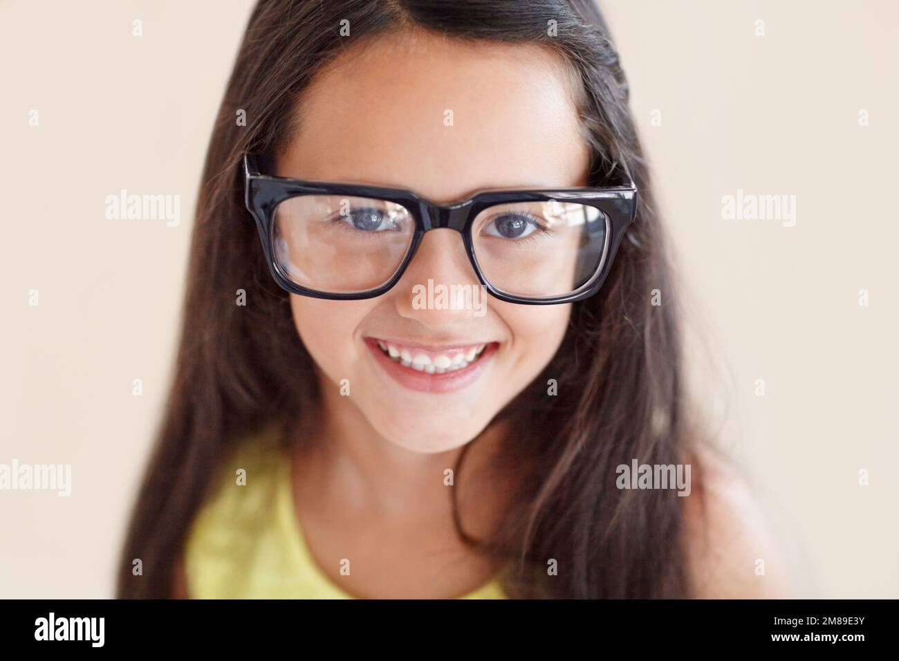 Ich werde in sie hineinwachsen... Nahporträt eines süßen jungen Mädchens, das eine große Brille trägt. Stockfoto